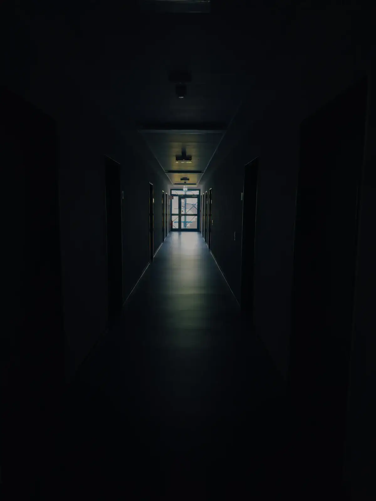 A dark corridor with light at the far end