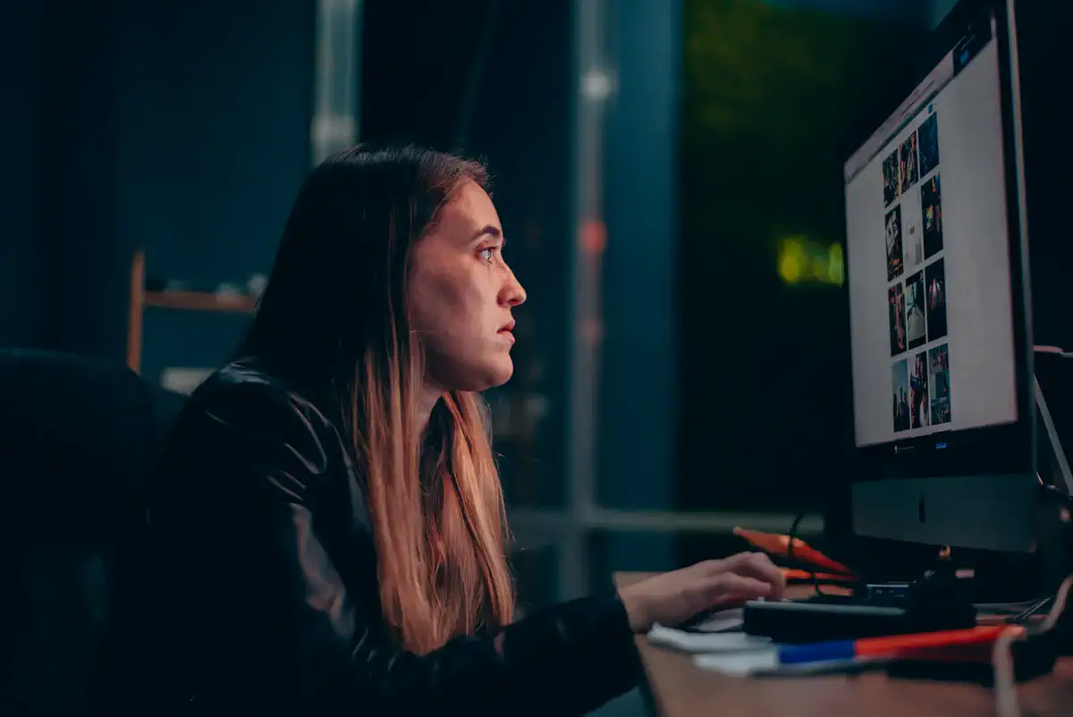 A woman reviewing work on a computer screen